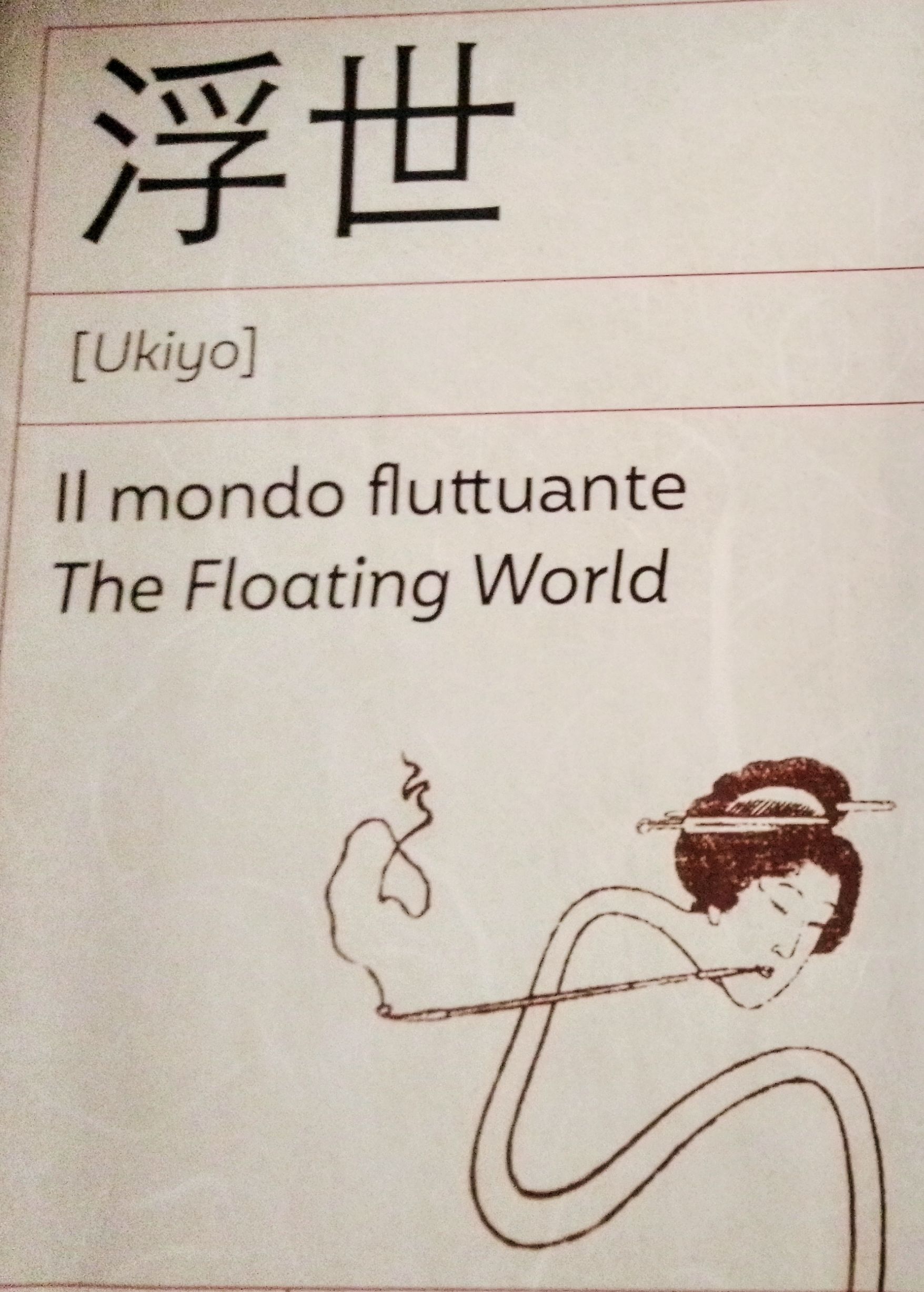 Scritto in kanji giapponesi troviamo la scritta Ukiyo, il mondo fluttuante, The flooting world. Sotto la scritta, in forma stilizzata una donna giapponese tiene in mano un pennello o una pipa che dal fumo scrive e disegna.