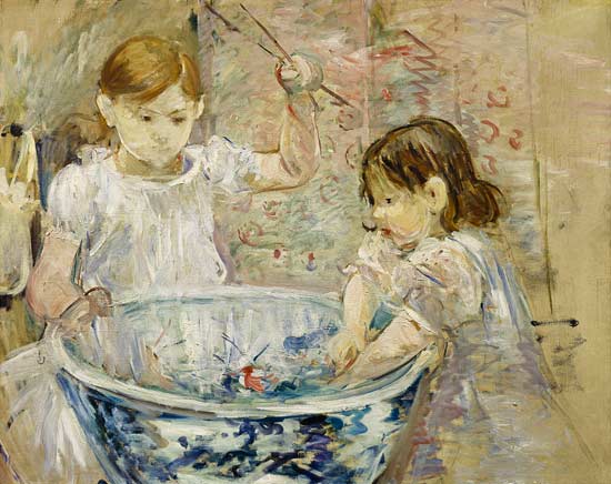 Due bambine stanno giocando con dei pesci un una bacinella.