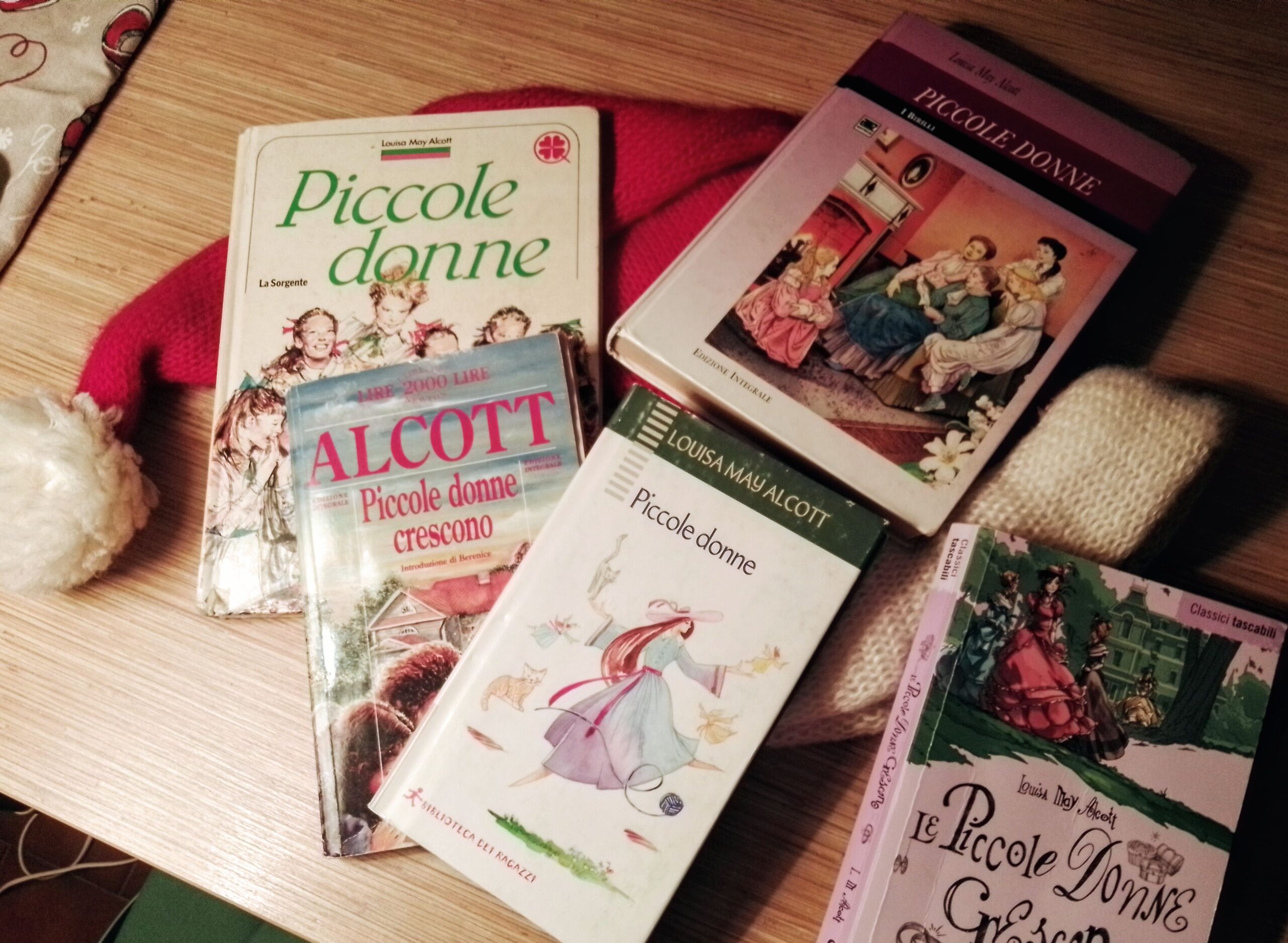 Varie edizioni dei libri di di Louisa May Alcott Piccole donne e Piccole Donne Crescono, adagiati sun cappello rosso e bianco di Babbo Natale