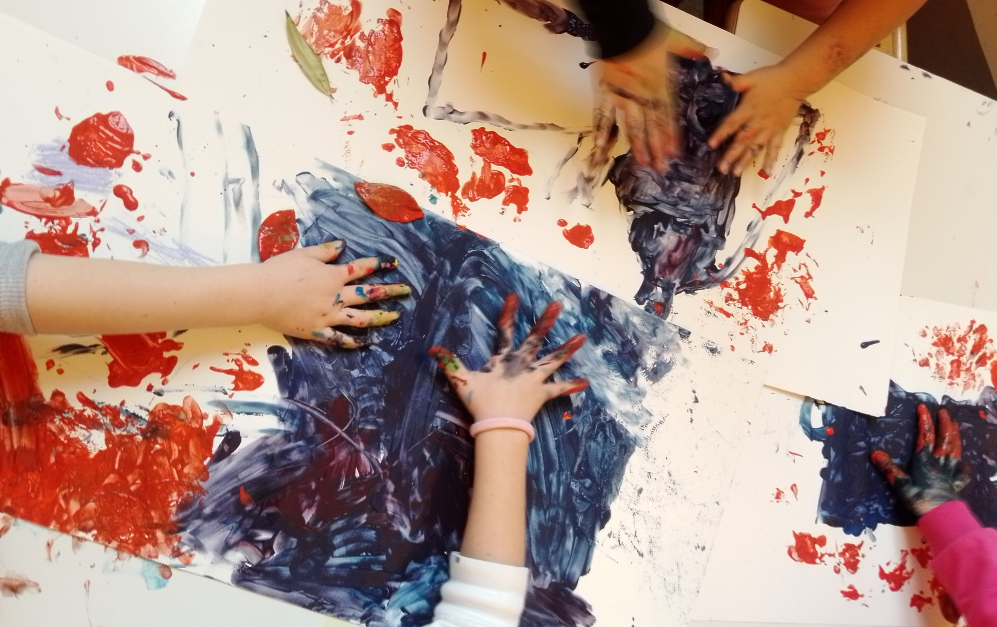Mani di bambini e bambine che dipingono